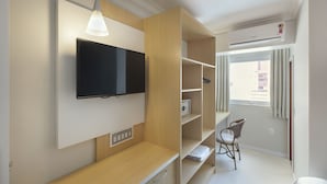 A modern room with a mounted TV, wooden shelves, a desk, and a chair. - Hotel Miramar (Balneário Camboriú)
