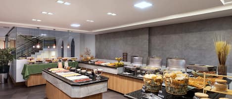A buffet setup with various food items and a staircase leading to an upper level.