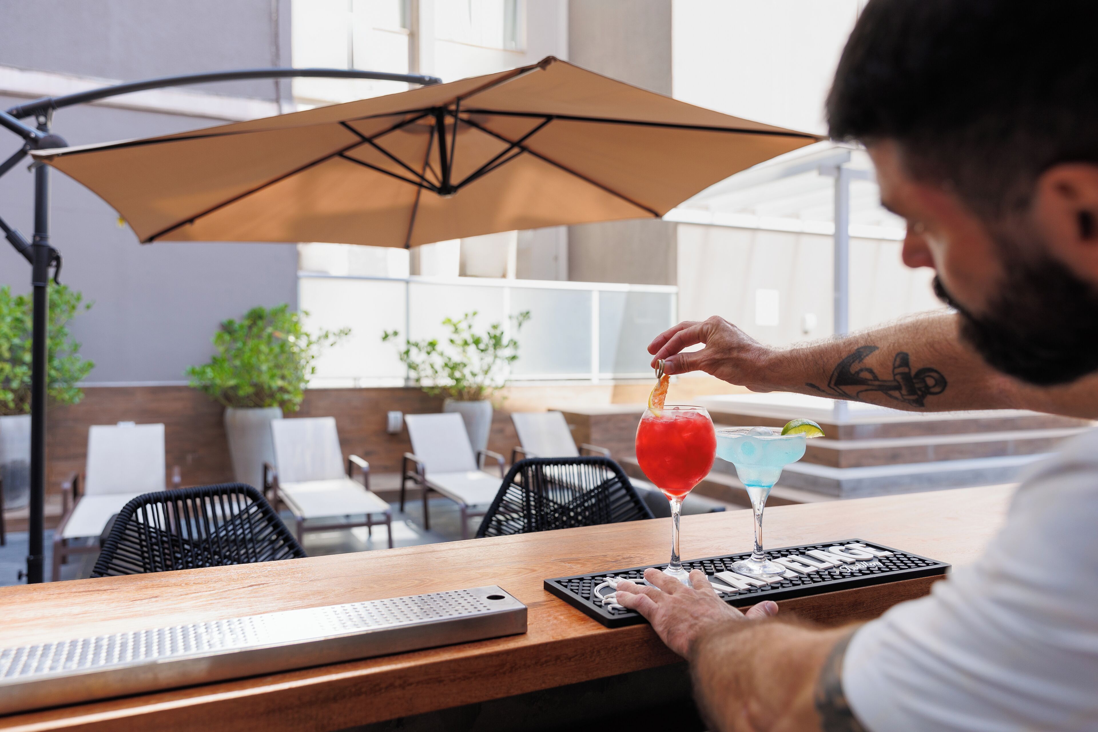 Una persona sentada a una mesa, con una bebida, un teclado y un menú.