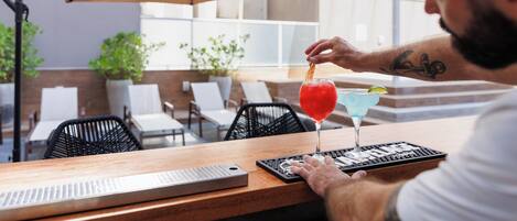 Una persona sentada a una mesa, con una bebida, un teclado y un menú.