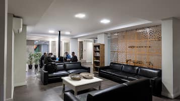 A modern lobby with leather sofas, a coffee table, and a decorative wooden partition.