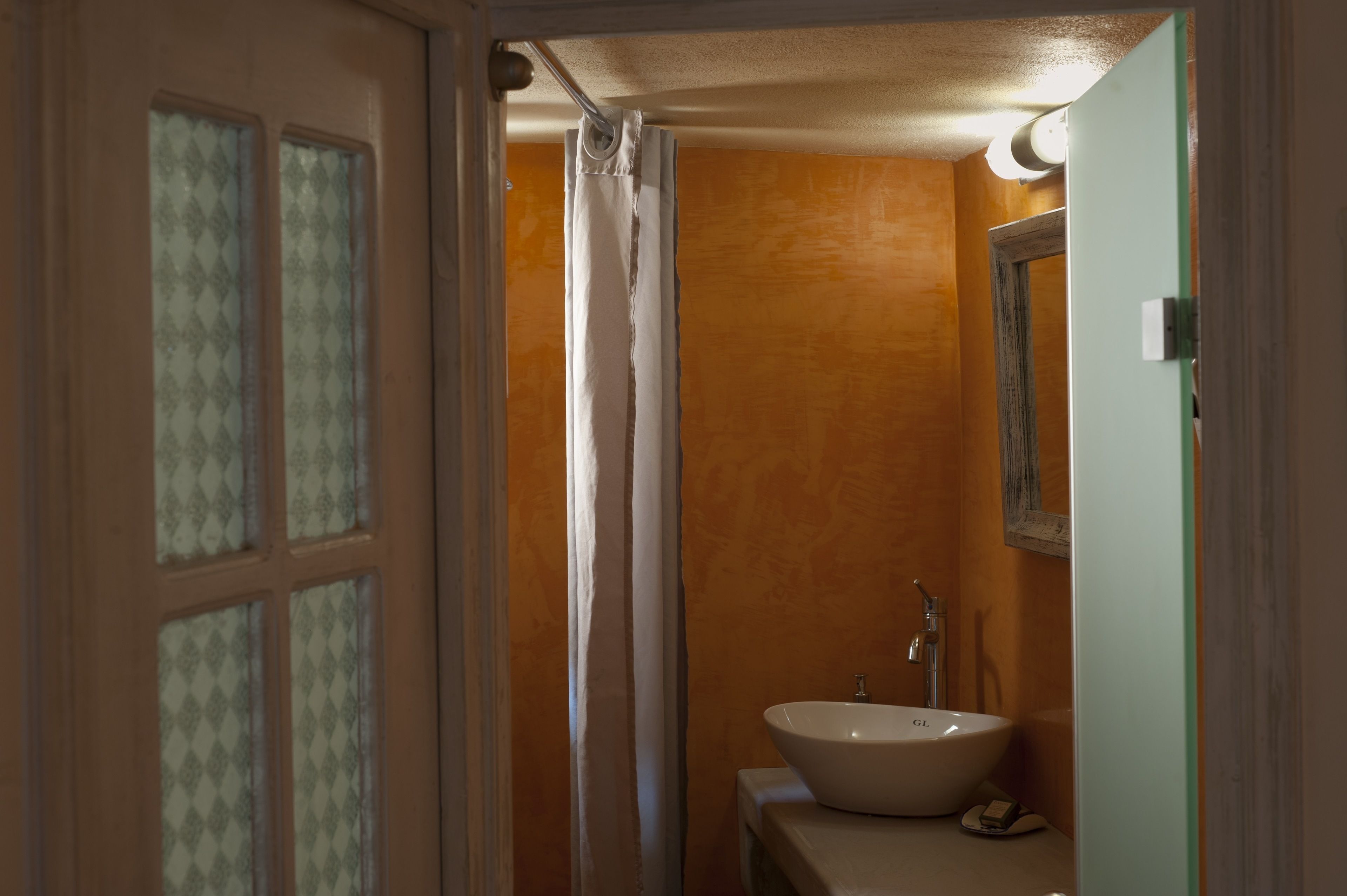 A bathroom with a white sink, a mirror, and a shower curtain.