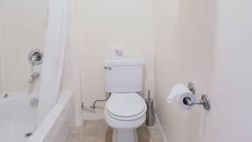 A bathroom with a bathtub, toilet, and a towel rack.