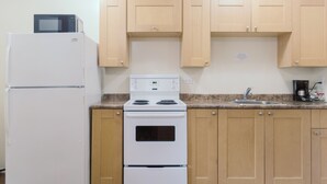 Une cuisine avec un réfrigérateur blanc, une cuisinière et des armoires en bois.