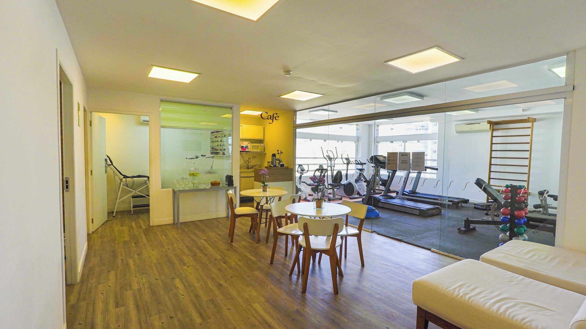 A modern interior with a dining area, exercise equipment, and a view of the outside.