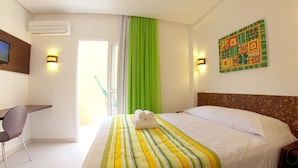A hotel room with a bed, a desk, a chair, a TV, and a painting on the wall. - Pousada Ecomaceio (Maceió)