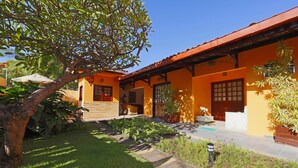 A courtyard with a wooden deck, a tree, and potted plants. - Pousada Casamar (Ipojuca)