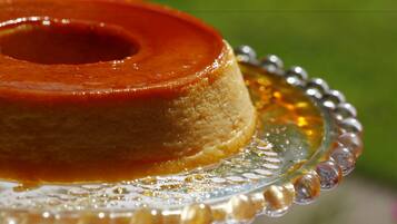 A caramel flan on a glass plate with a decorative edge.