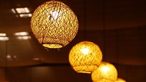 A series of spherical hanging lights with a textured pattern, suspended from the ceiling in a room with a staircase and seating area. - Pousada Casamar (Ipojuca)