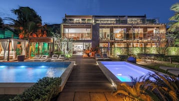 Una piscina al aire libre, sillones reclinables de piscina