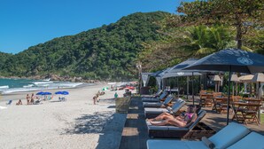 På stranden, solsenger, parasoller og strandhåndklær