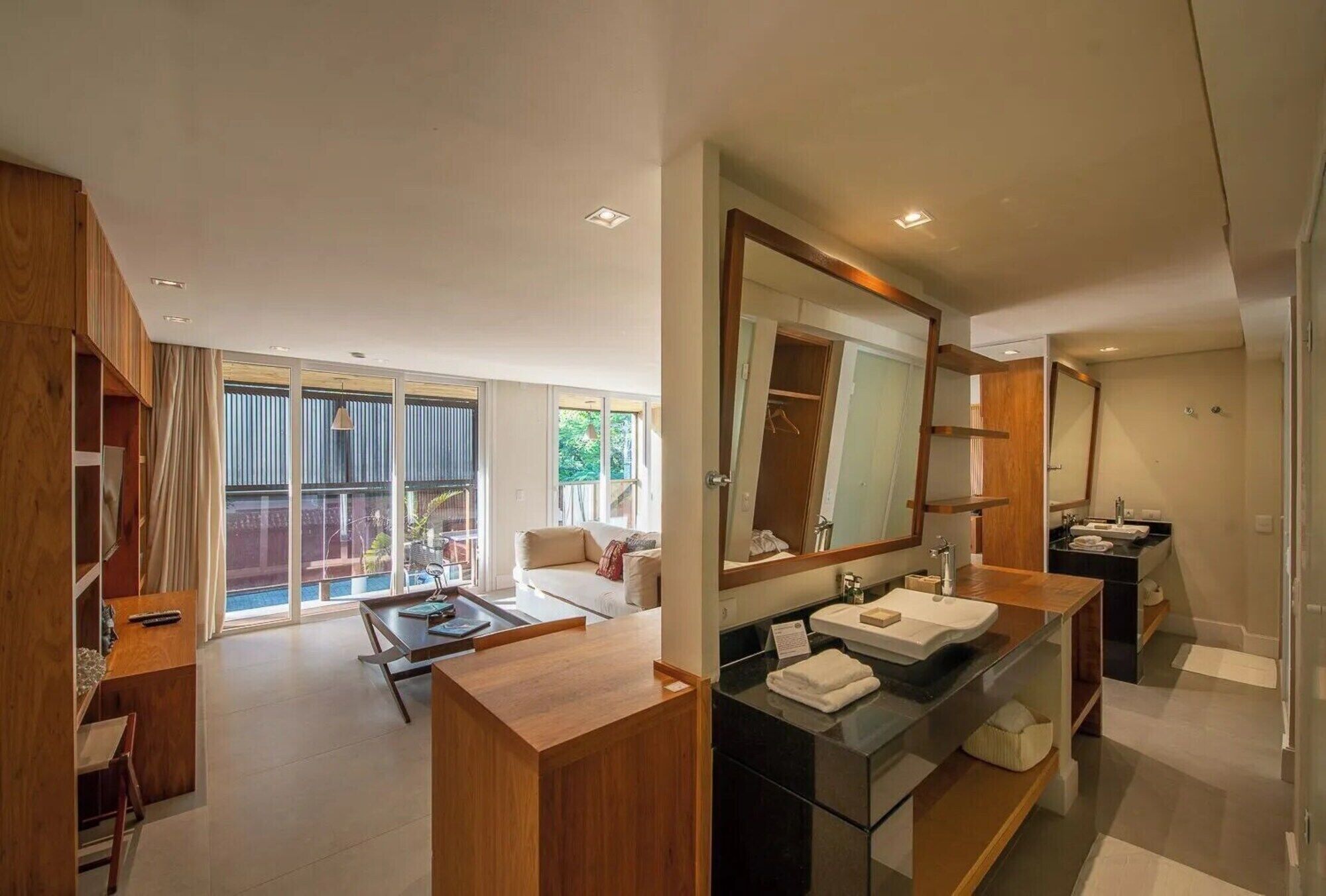 Un baño moderno con un espejo grande, lavamanos dobles y un mueble de tocador de madera.