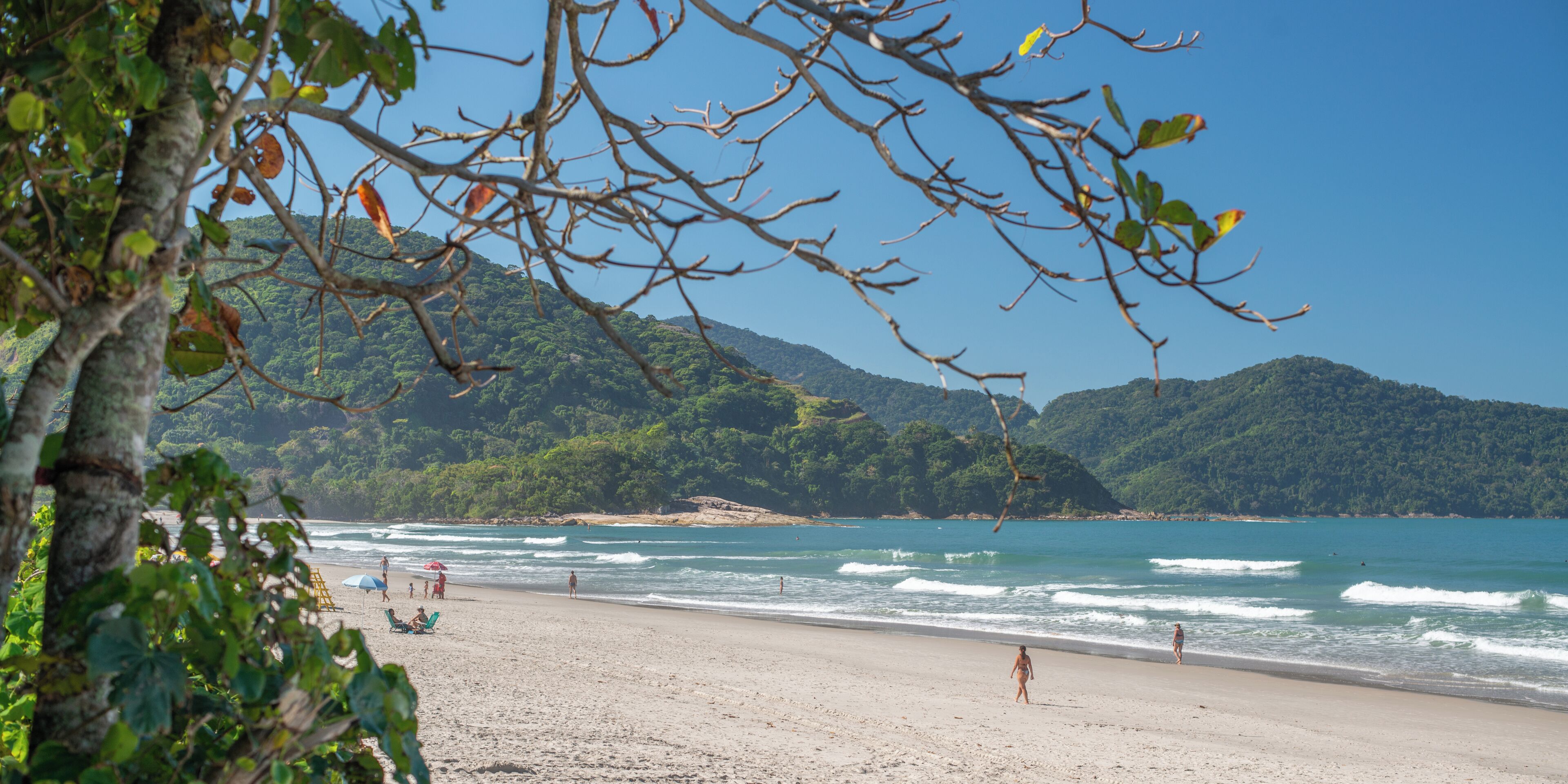 Na praia, espreguiçadeiras, guarda-sóis, toalhas de praia 