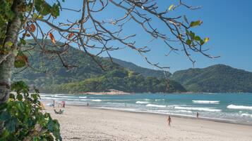 Na praia, espreguiçadeiras, guarda-sóis, toalhas de praia