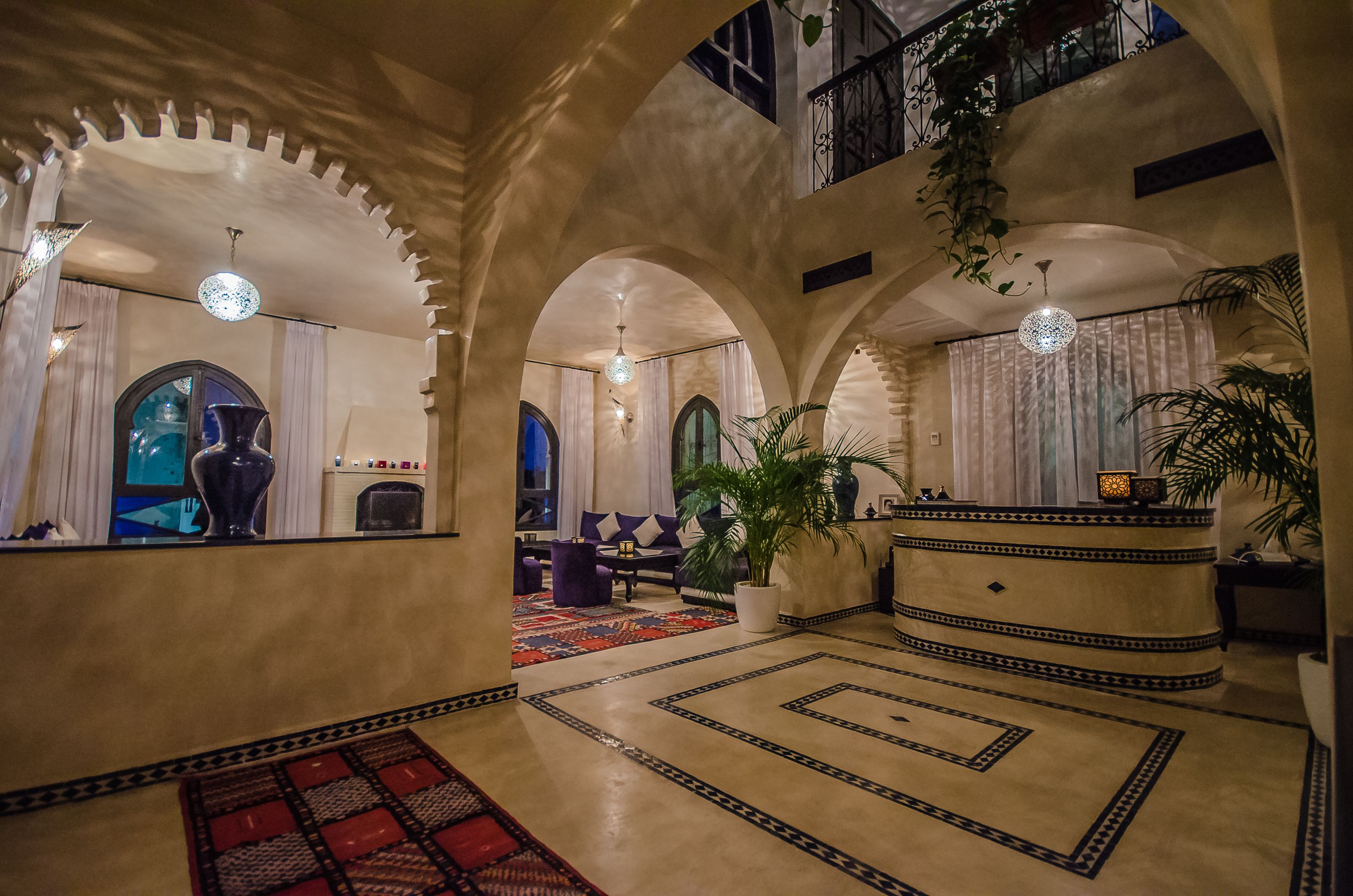 A spacious lobby with arched ceilings, a central seating area, and a reception desk.
