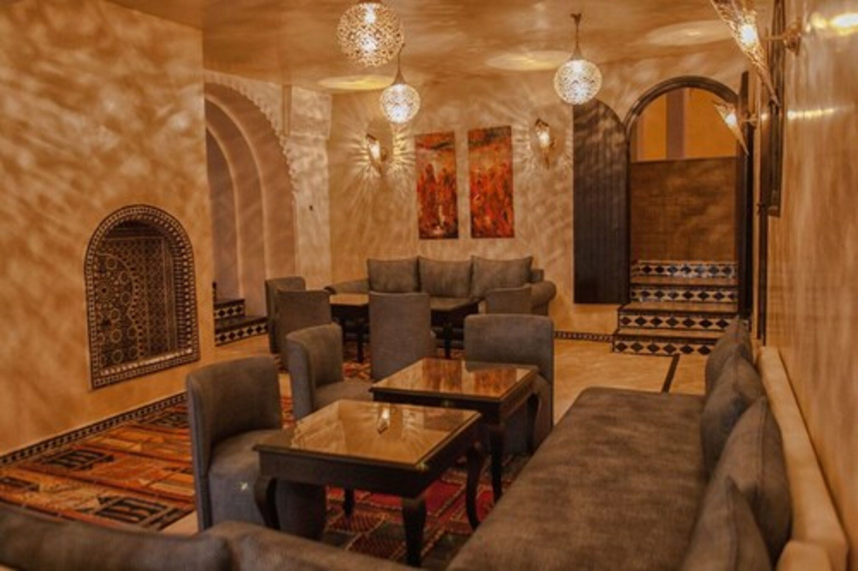 A lounge area with sofas, tables, and patterned rugs.