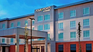 A modern hotel with a flat roof, multiple windows, and a prominent signage for 'Four Points by Sheraton'. - Four Points by Sheraton Edmonton International Airport (Nisku)