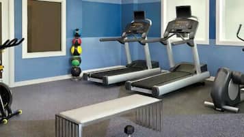 A gym with treadmills, stationary bikes, and a rowing machine.