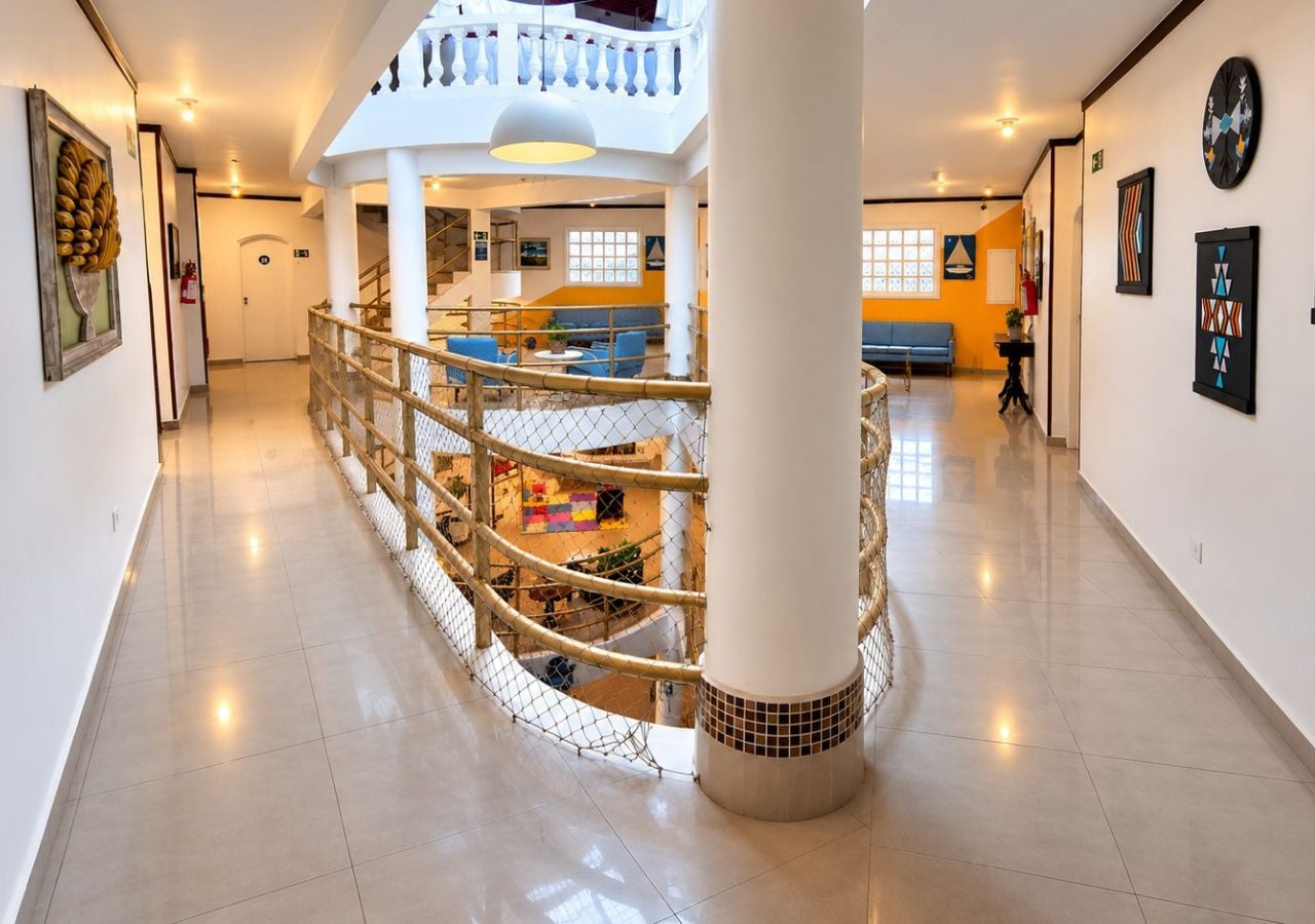 Eine großzügige Lobby mit einem zentralen Atrium, einer Treppe und einer Sitzecke.