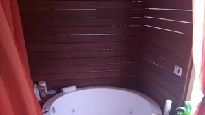 Un jacuzzi en una cabaña de madera con una toalla colgando.