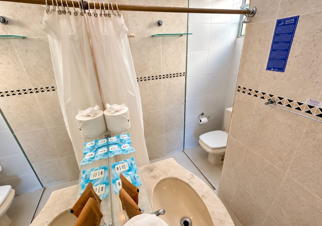 Un baño con cortina de ducha, bañera, inodoro y cabina de ducha de vidrio.