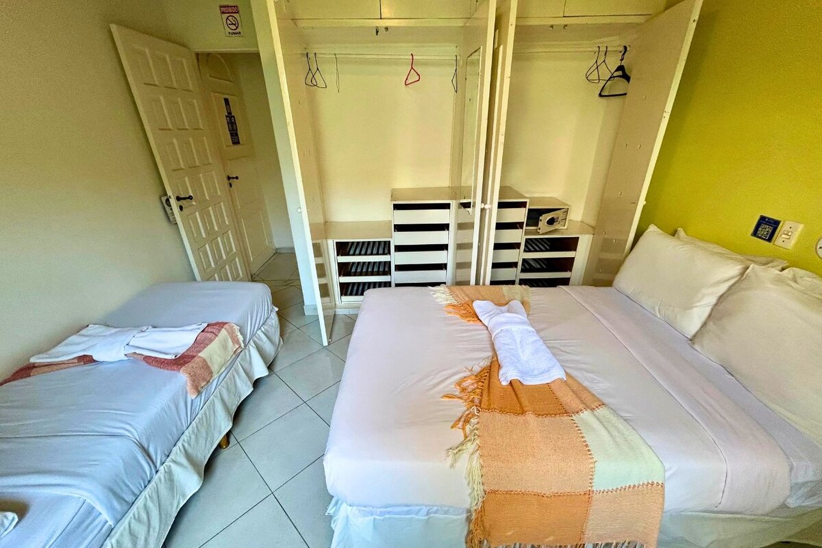 Una habitación con dos camas, un armario y un espacio de almacenamiento.