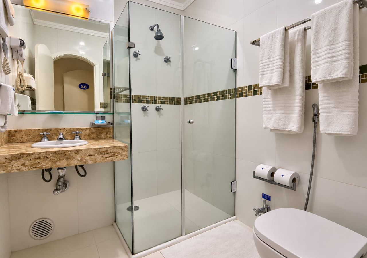 A modern bathroom with a glass-enclosed shower, a sink with a vanity, and a toilet.