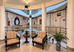 A lobby with two armchairs, a small table, and a potted plant.