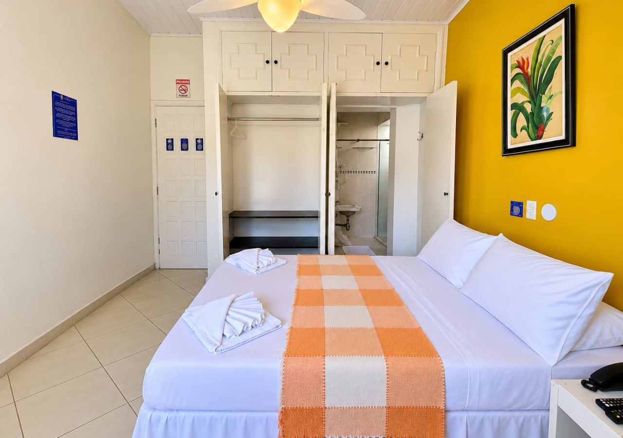Ein Hotelzimmer mit Bett, Kleiderschrank, Duschbereich und Badezimmer.