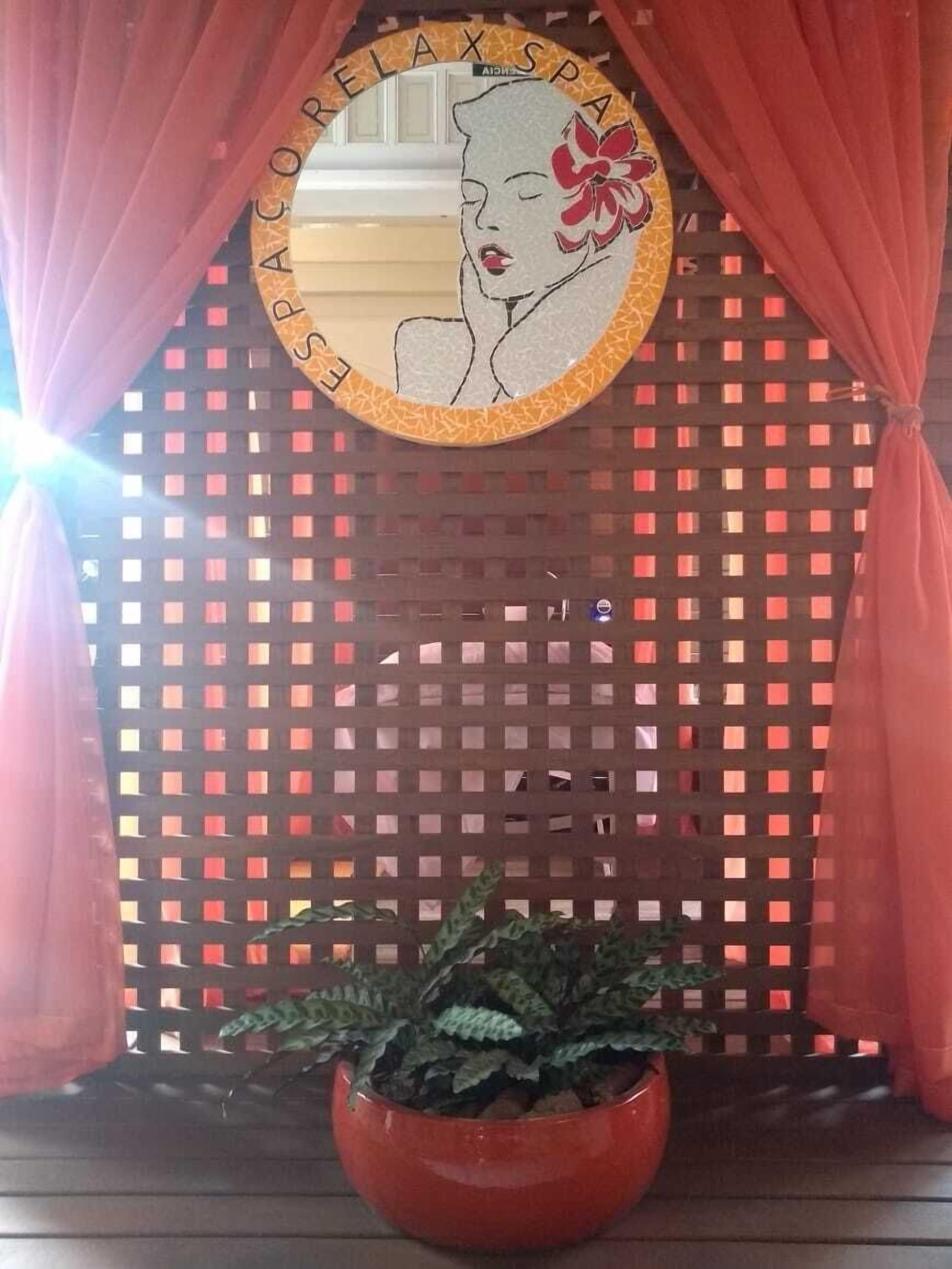 A spa area with a circular mirror featuring a floral design and the words "RELAX SPA".