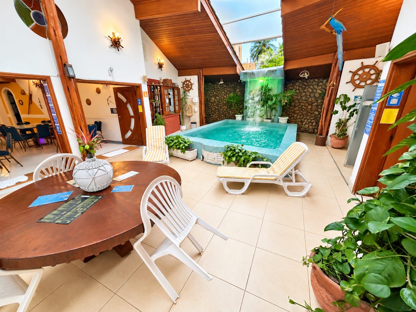 A pool area with a hot tub, lounge chairs, and a dining table with chairs.