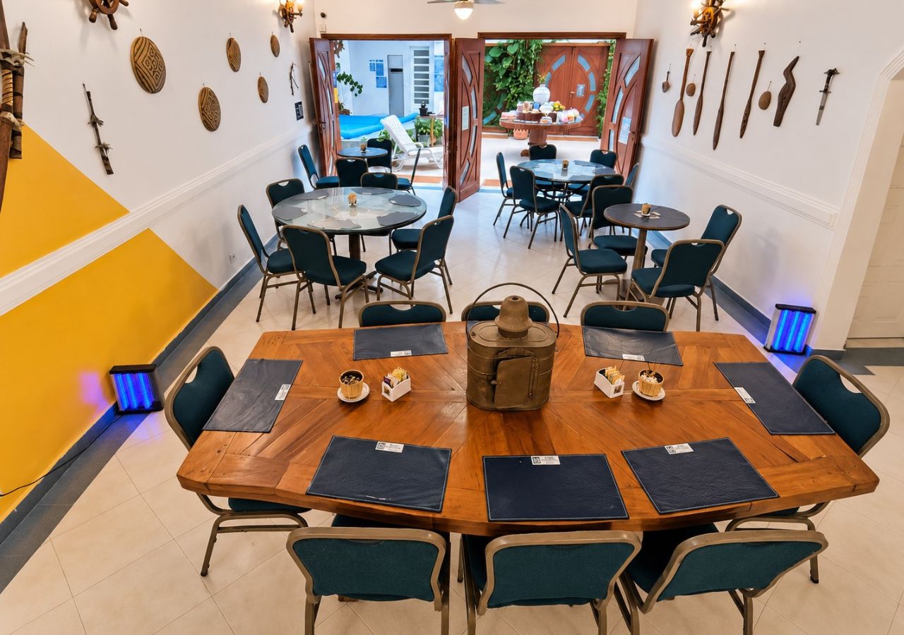 A conference room with a large wooden table, multiple chairs, and a central decorative item.