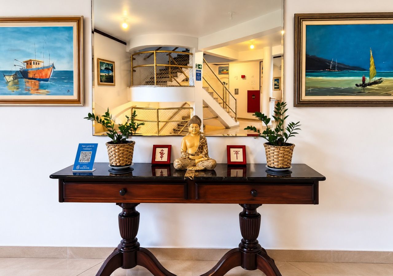 A reception desk with a Buddha statue, framed artwork, and potted plants.