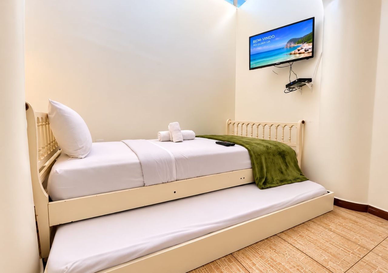 A bunk bed with a television mounted on the wall above it.