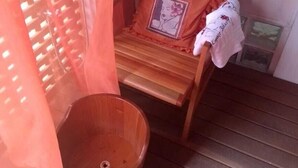 A wooden chair with a cushion and a small wooden basin. - Hotel Casa Branca (Guarujá)