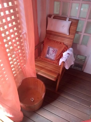 Une chaise en bois avec un coussin et un petit récipient en bois.