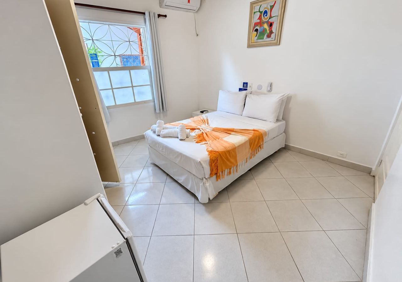 Un dormitorio con cama, ventana y puerta.