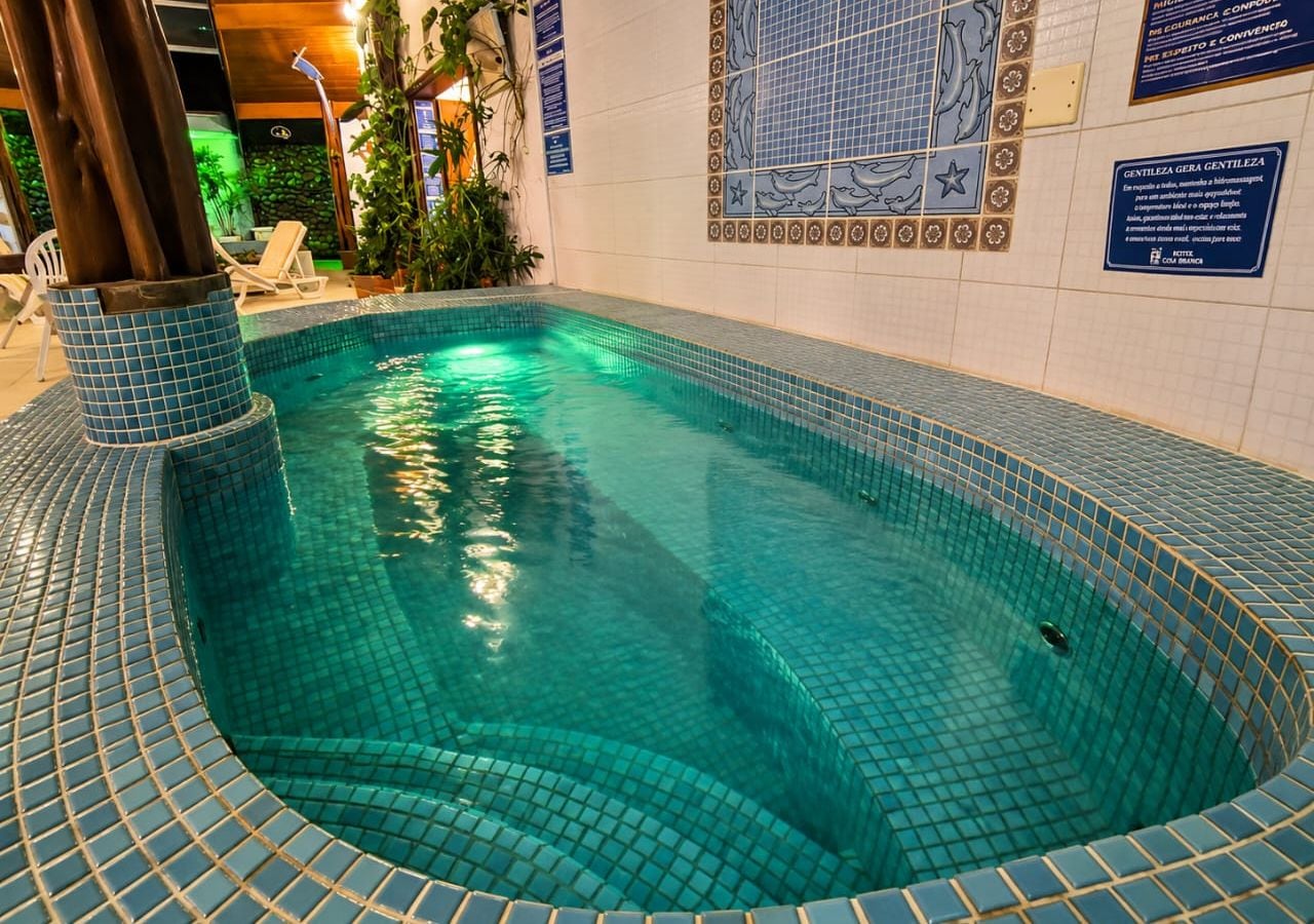Une piscine intérieure dont les murs et le sol sont recouverts de carreaux.