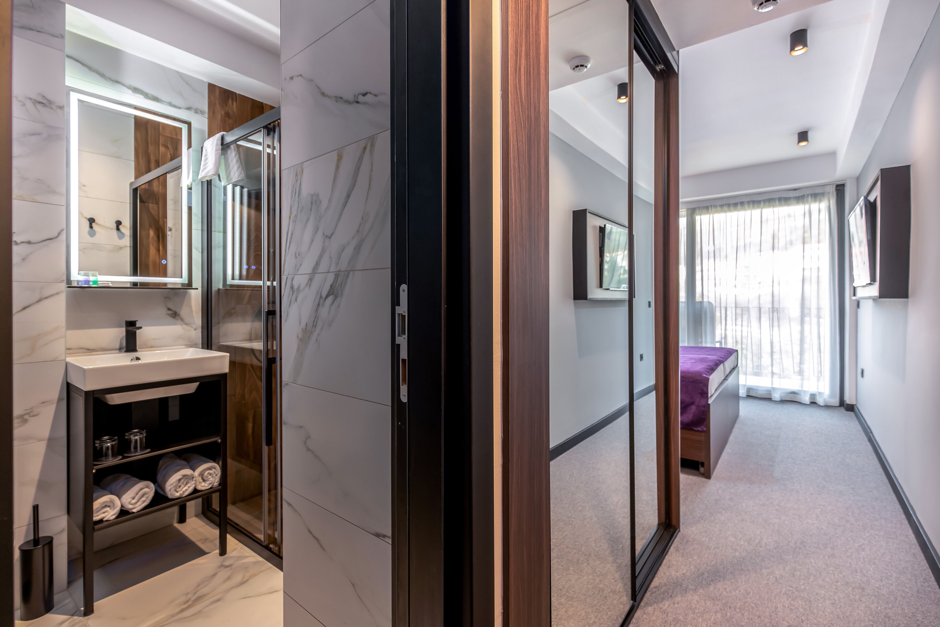 A modern bathroom with a vanity, mirror, and shower.