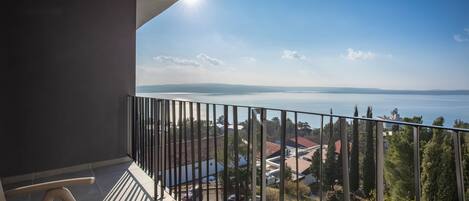 A balcony with a view of a body of water and buildings in the distance.