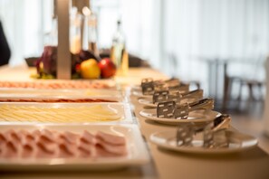 A buffet table with various food items and plates. - Hotel Ad Turres (Crikvenica)