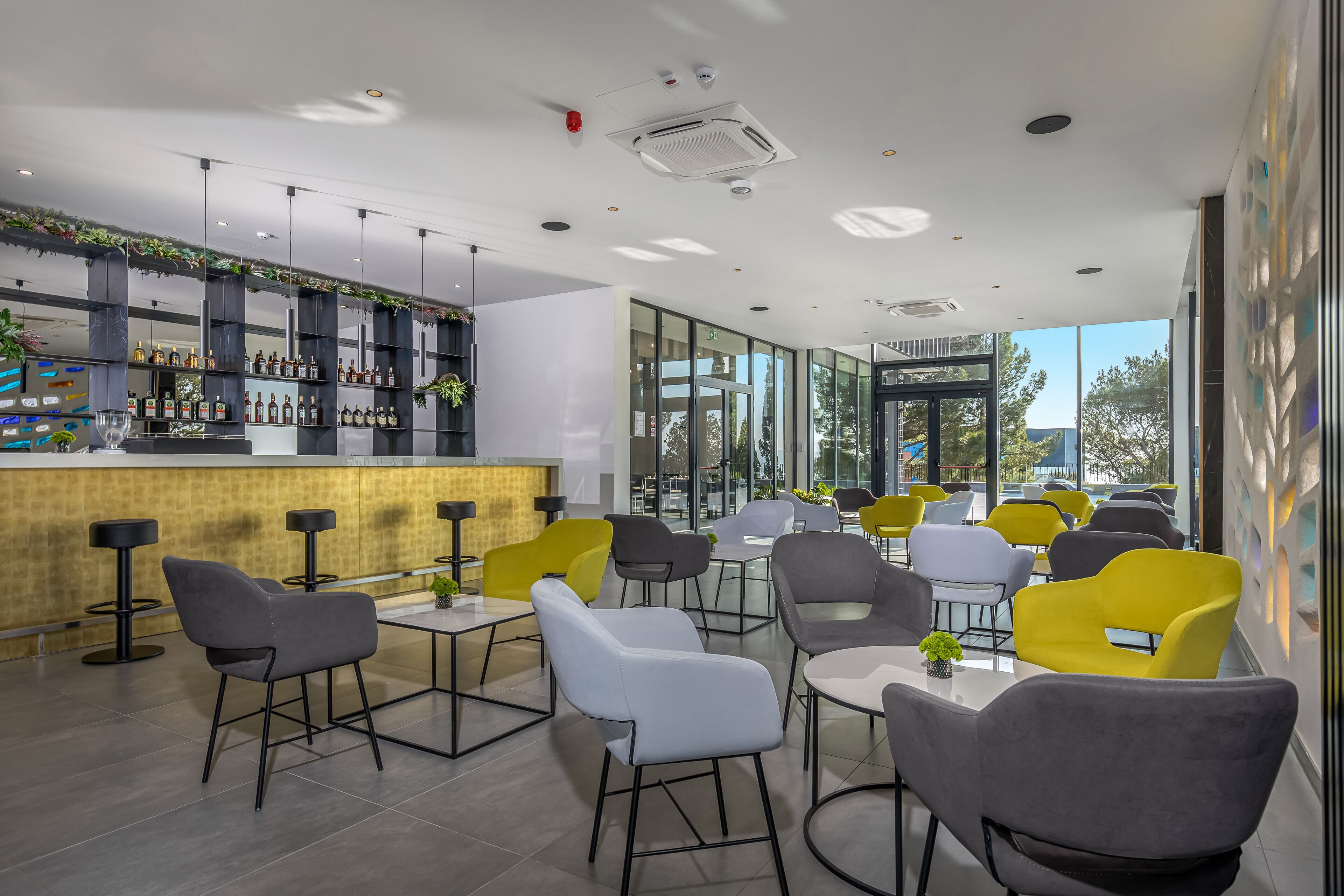 A modern bar area with a variety of seating options and a well-stocked liquor display.