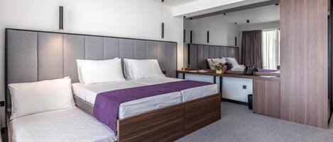 Una habitación de hotel moderna con una cama grande, un escritorio y un espejo.