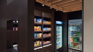 A snack display with various packaged goods and a refrigerated beverage cooler.