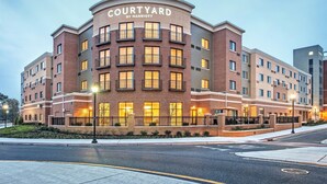 A multi-story hotel with a curved facade, multiple balconies, and a well-lit entrance.