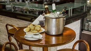 Una zona de bar con una mesa redonda, dos taburetes, una olla de metal grande y un plato de comida.