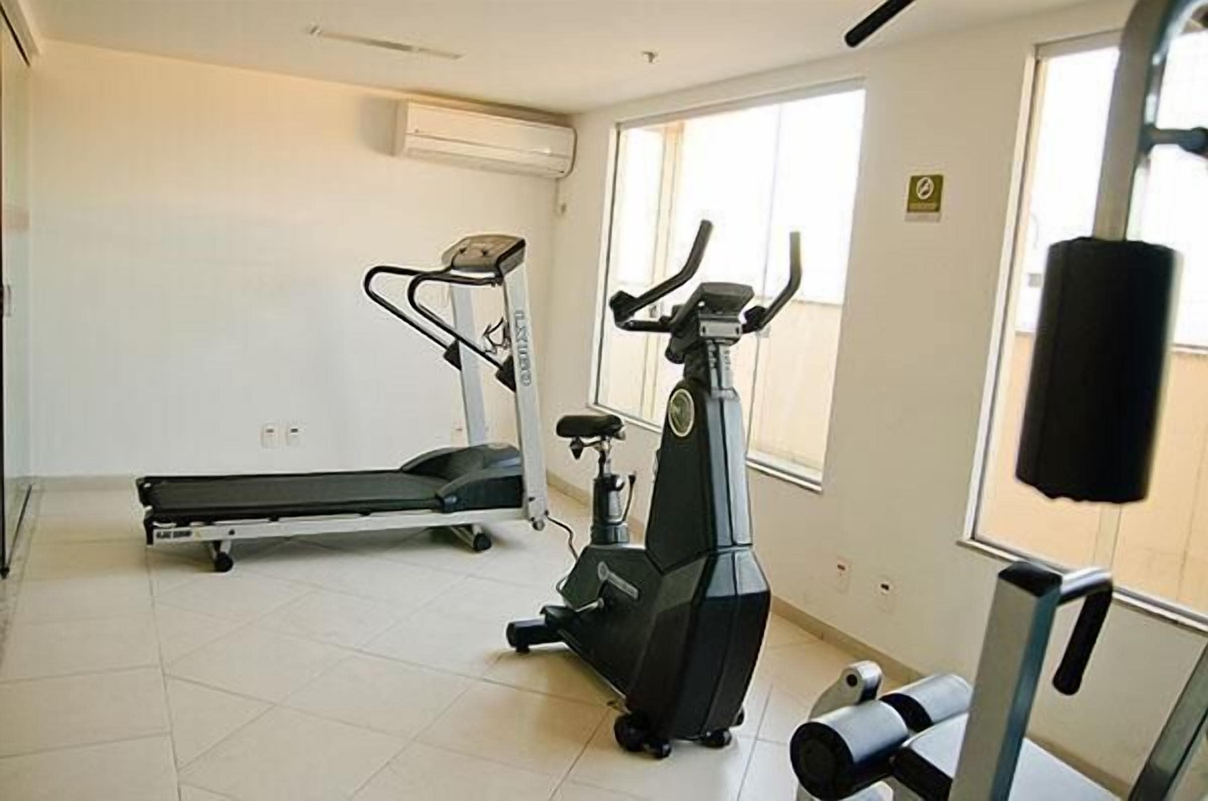 A gym with a treadmill, elliptical, and stationary bike.