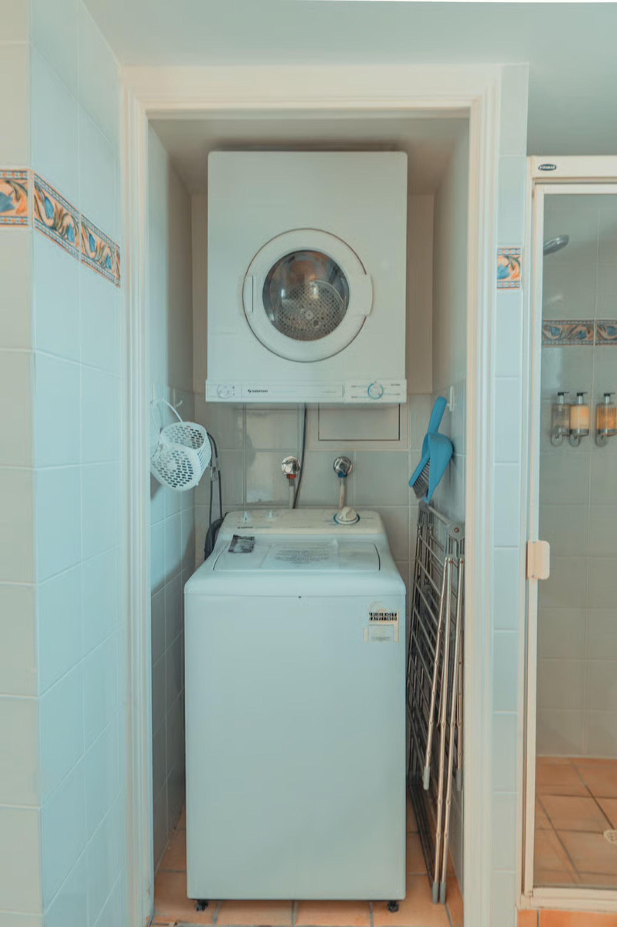 A compact laundry room with a washing machine, a dryer, and a small sink.