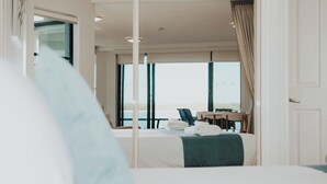 A hotel room with a bed, a desk, and a view of the sea. - La Promenade Absolute Waterfront Apartments (Caloundra)