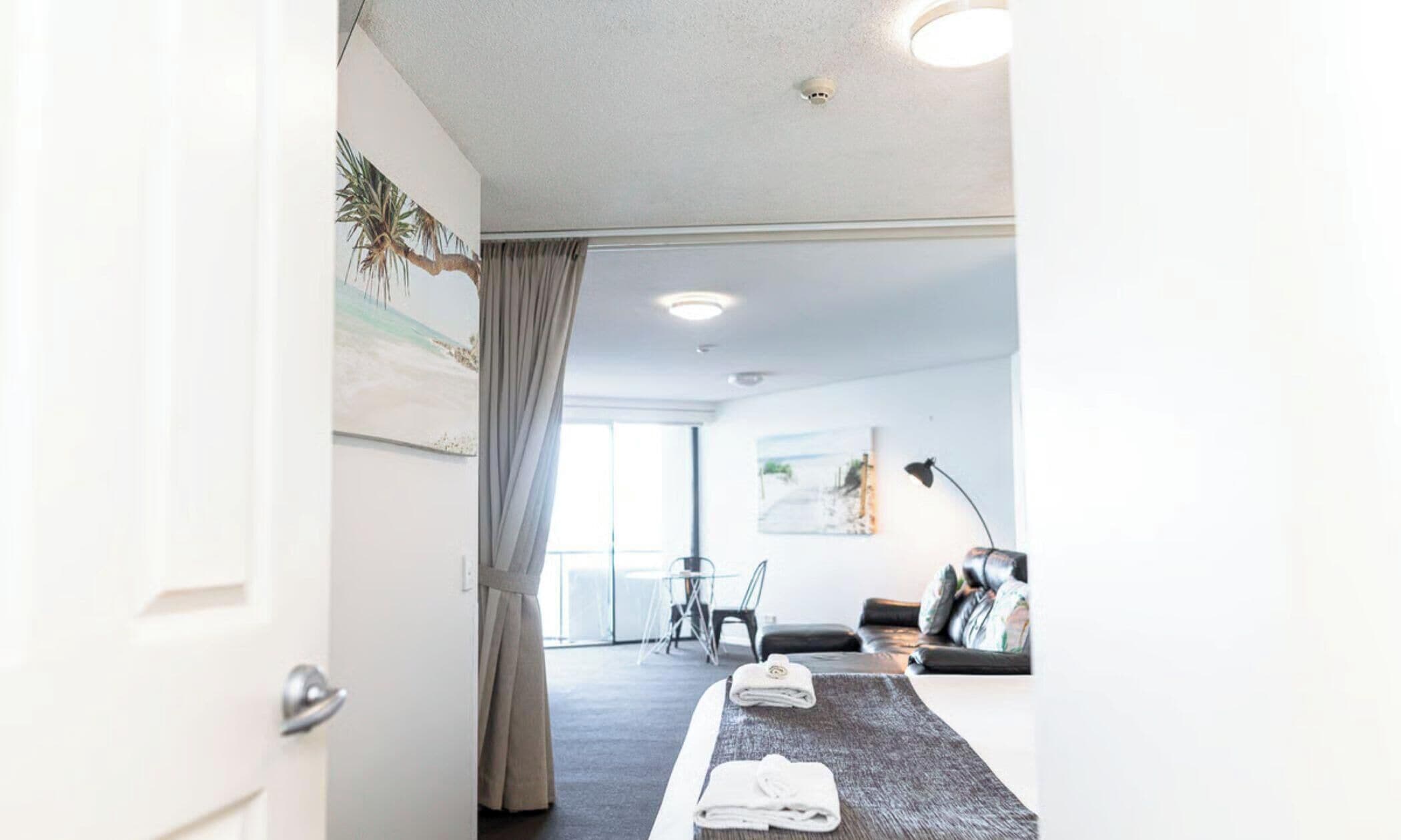 Et moderne hotelværelse med en seng, et siddeområde med sofa og bord, samt et stort vindue.